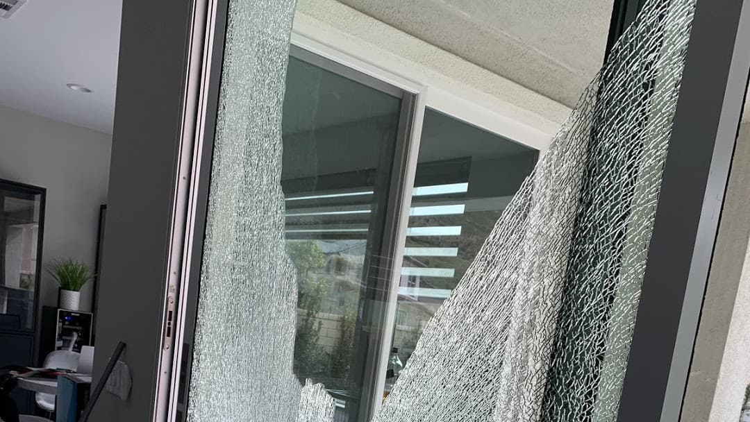 Shattered window glass with impact points in a metal frame