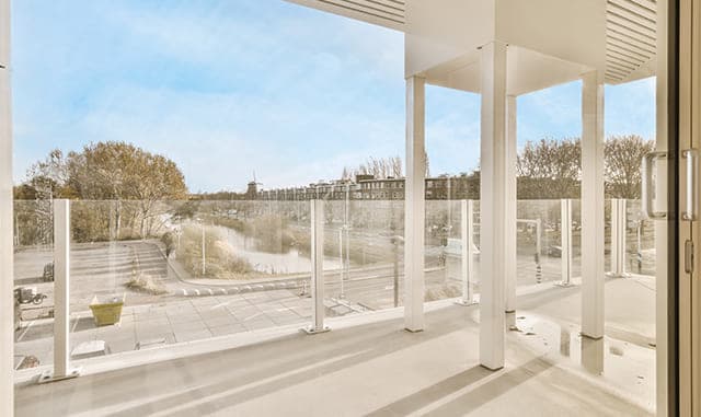 Commercial glass deck railing overlooking an outdoor terrace