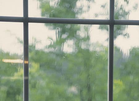 Close-up of fogged window glass with condensation droplets on the pane